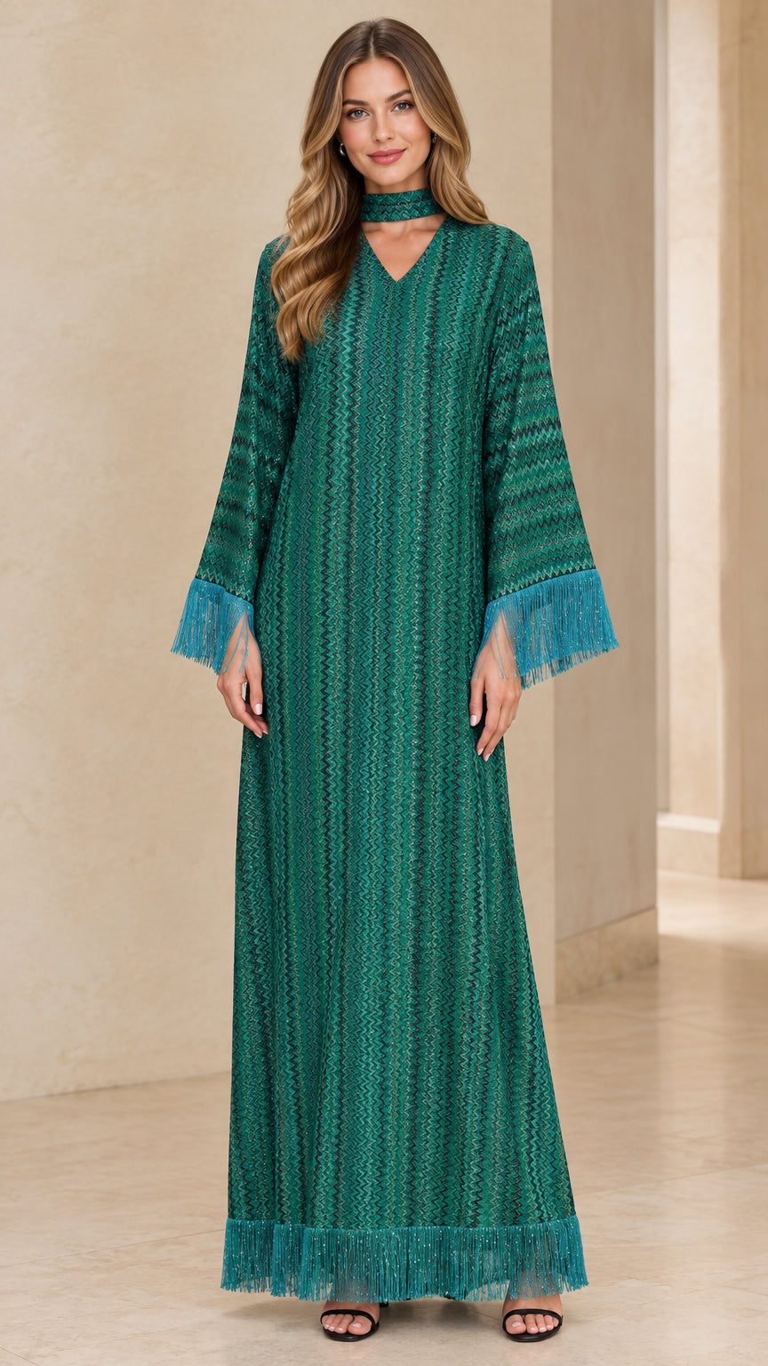 Front full view of woman wearing emerald green long sleeve chevron maxi dress with fringe trim and choker neckband