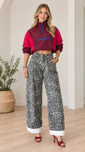 Front full view of woman wearing burgundy cropped half-zip windbreaker and leopard print wide-leg pants with heels