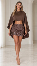 Front view of model wearing brown cape crop top and sequin disc mini skirt two-piece set