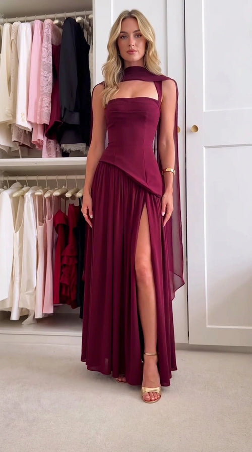 Front view of model wearing burgundy corset bodice maxi dress with neck drape and side slit