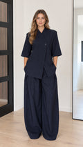 Front view of model wearing Navy Blue asymmetrical short sleeve top and wide-leg pants set