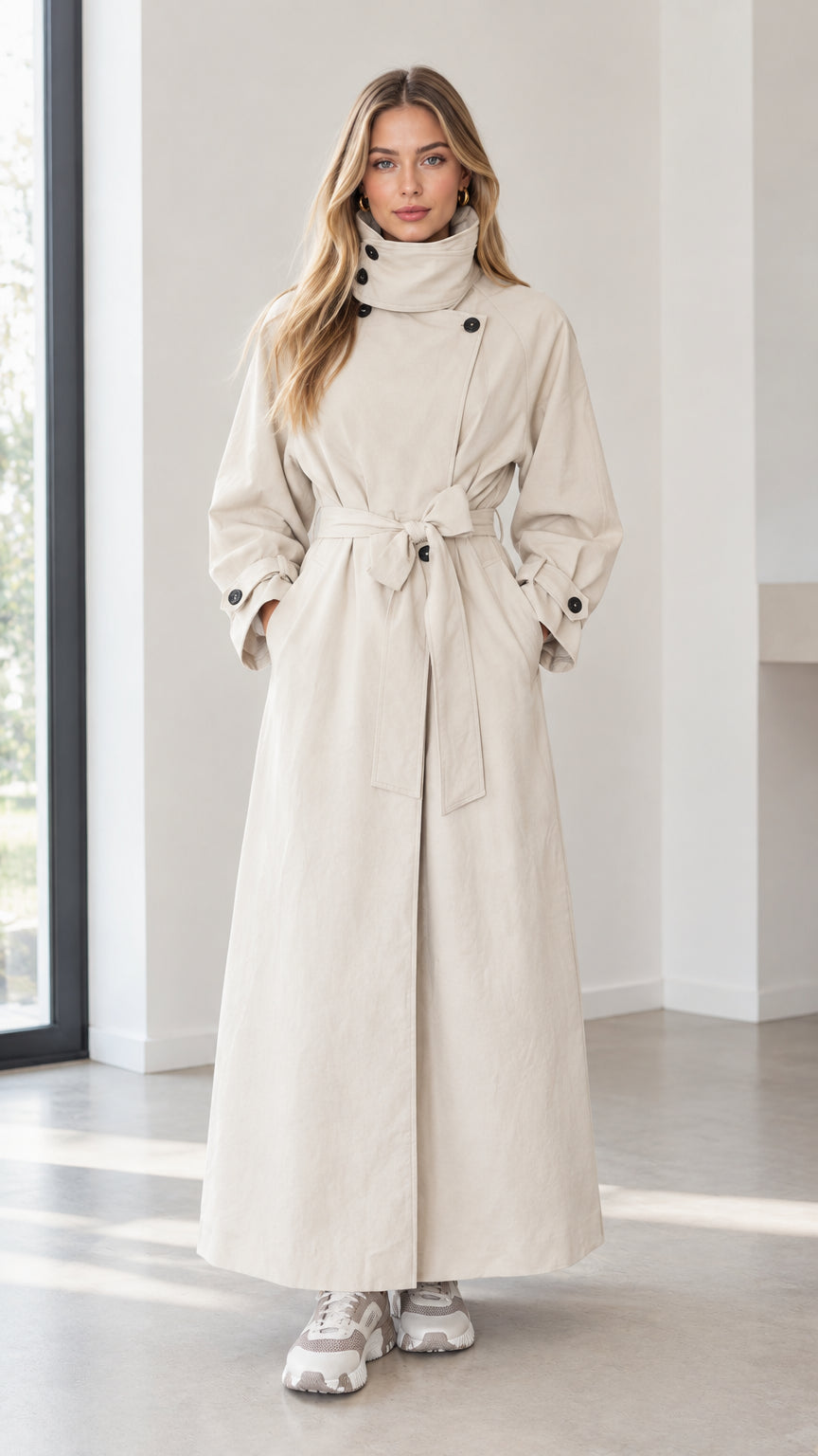 Front full-length view of woman wearing beige high-neck belted maxi trench coat