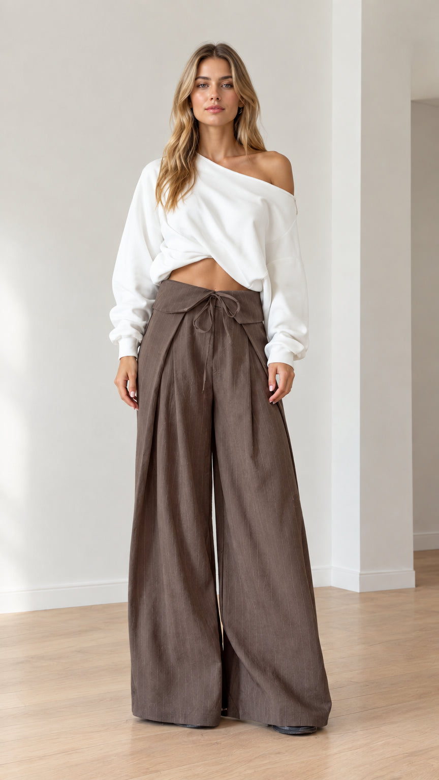 Model wearing white off-shoulder top and brown fold-over tie wide-leg pants front view