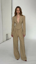 Front view of model wearing beige cropped blazer and wide leg trousers pant suit set