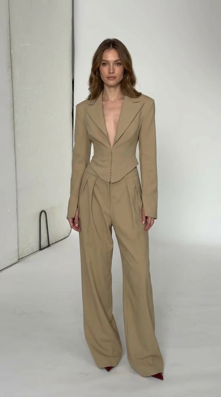 Front view of model wearing beige cropped blazer and wide leg trousers pant suit set