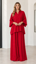 Front full-length view of woman wearing red oversized button-down shirt and matching wide-leg pants set