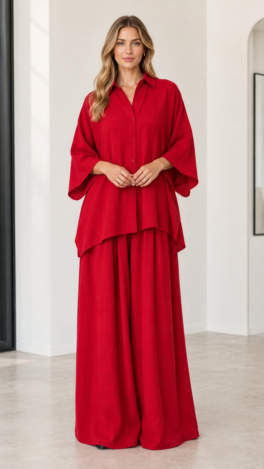 Front full-length view of woman wearing red oversized button-down shirt and matching wide-leg pants set