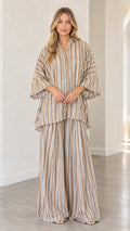 Front view of woman wearing beige striped oversized tunic shirt and wide-leg matching pants set