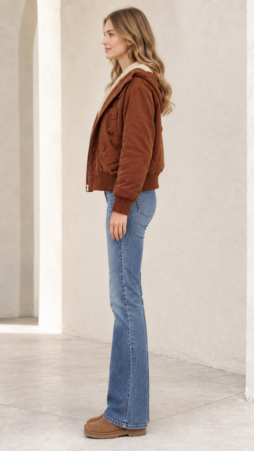 Side profile view of woman wearing brown fleece-lined zip bomber jacket