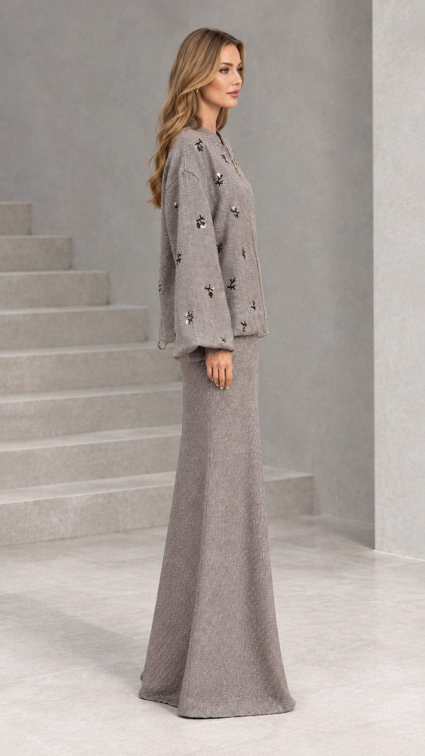 Side profile view of taupe herringbone jacket and full-length maxi skirt