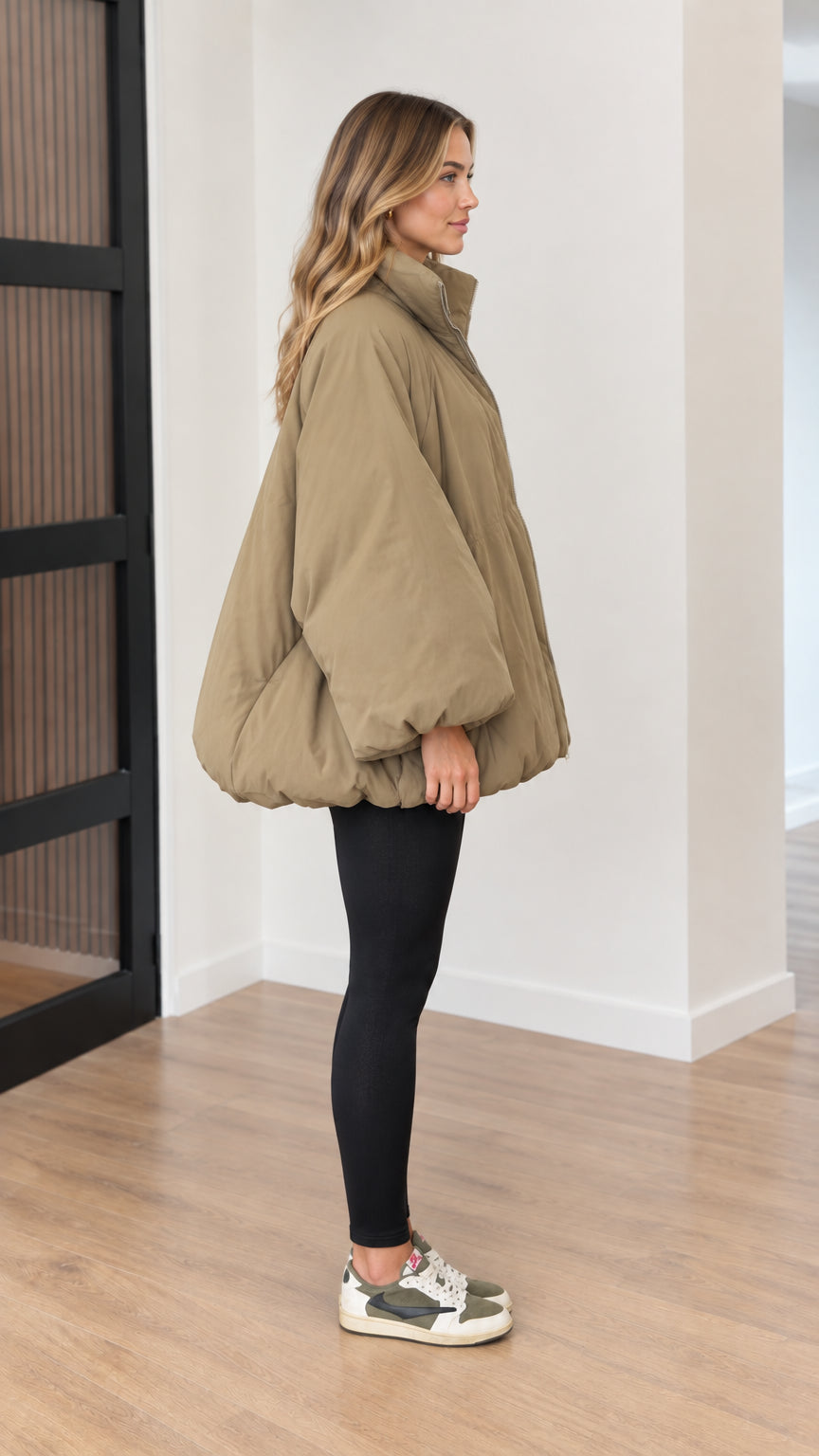 Side profile view of oversized khaki cocoon puffer jacket showing batwing sleeve and bubble hem