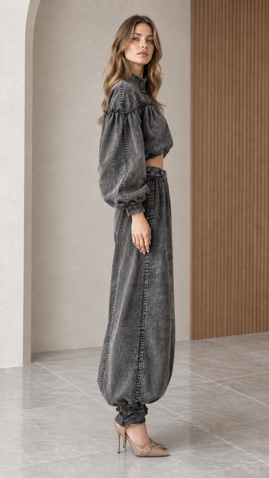 Side profile view of model showcasing the voluminous balloon pants and cropped denim top in charcoal gray