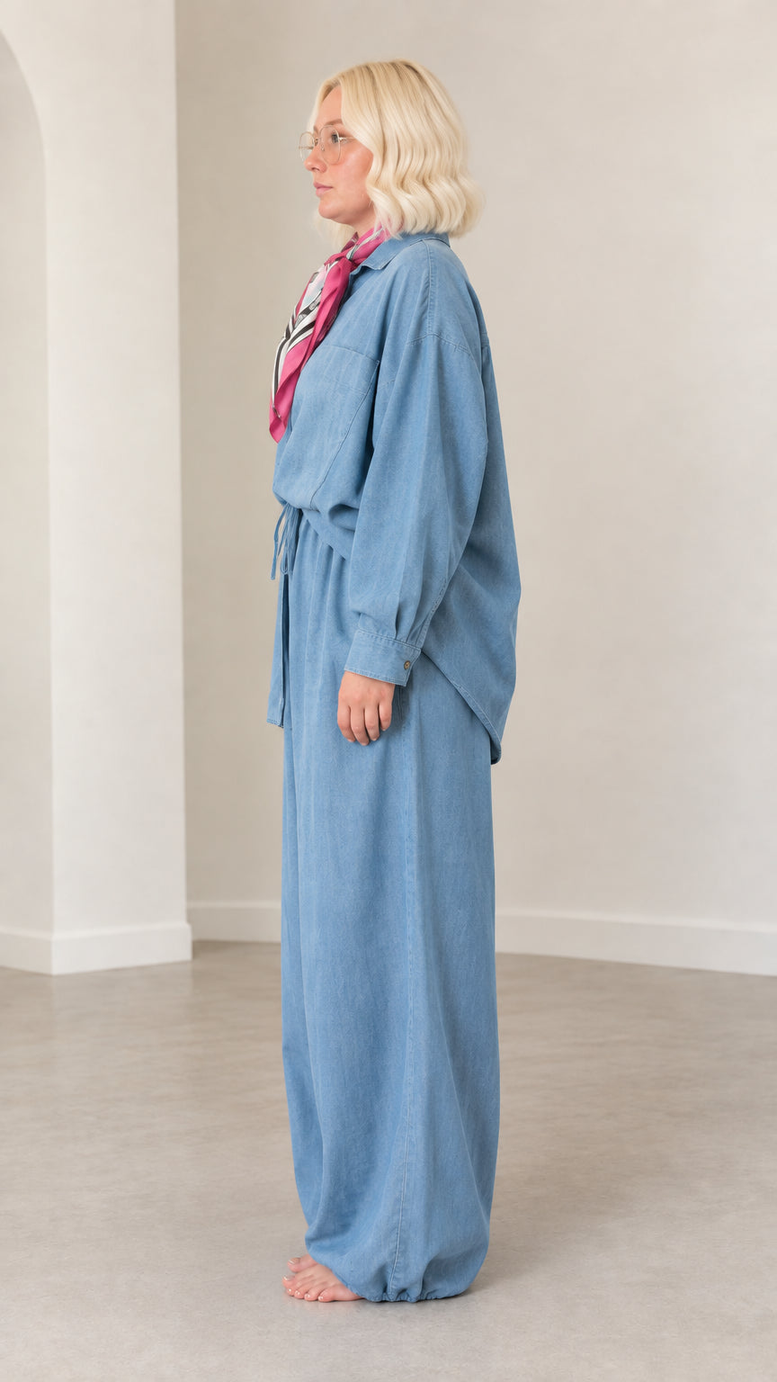 Side profile view of model wearing Light Blue two-piece shirt and drawstring trousers set