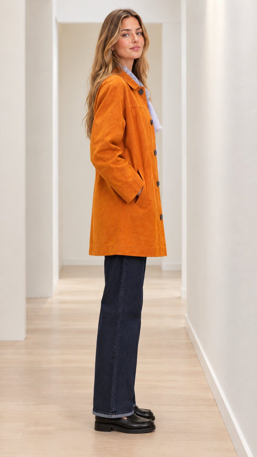 Side angle view of woman modeling cognac mid-length coat