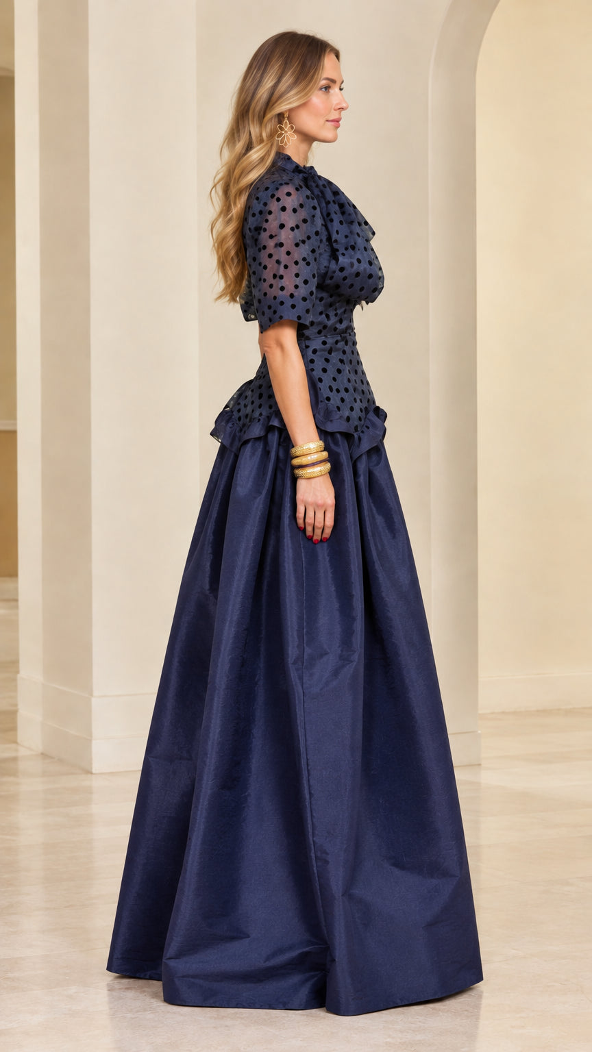 Model wearing navy blue polka dot peplum maxi dress - side profile