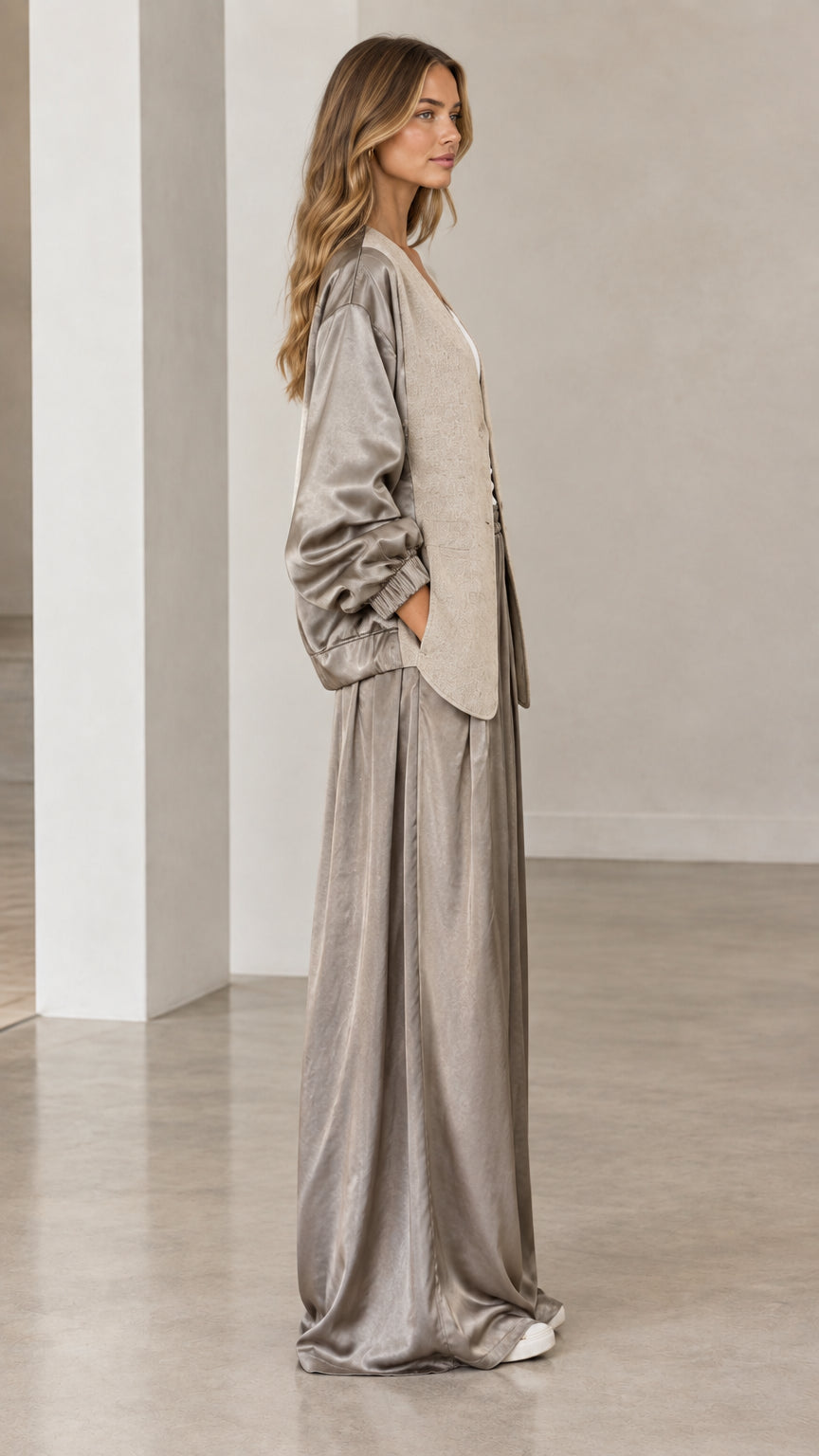 Side full-length view of woman in taupe satin wide-leg pants and relaxed jacket
