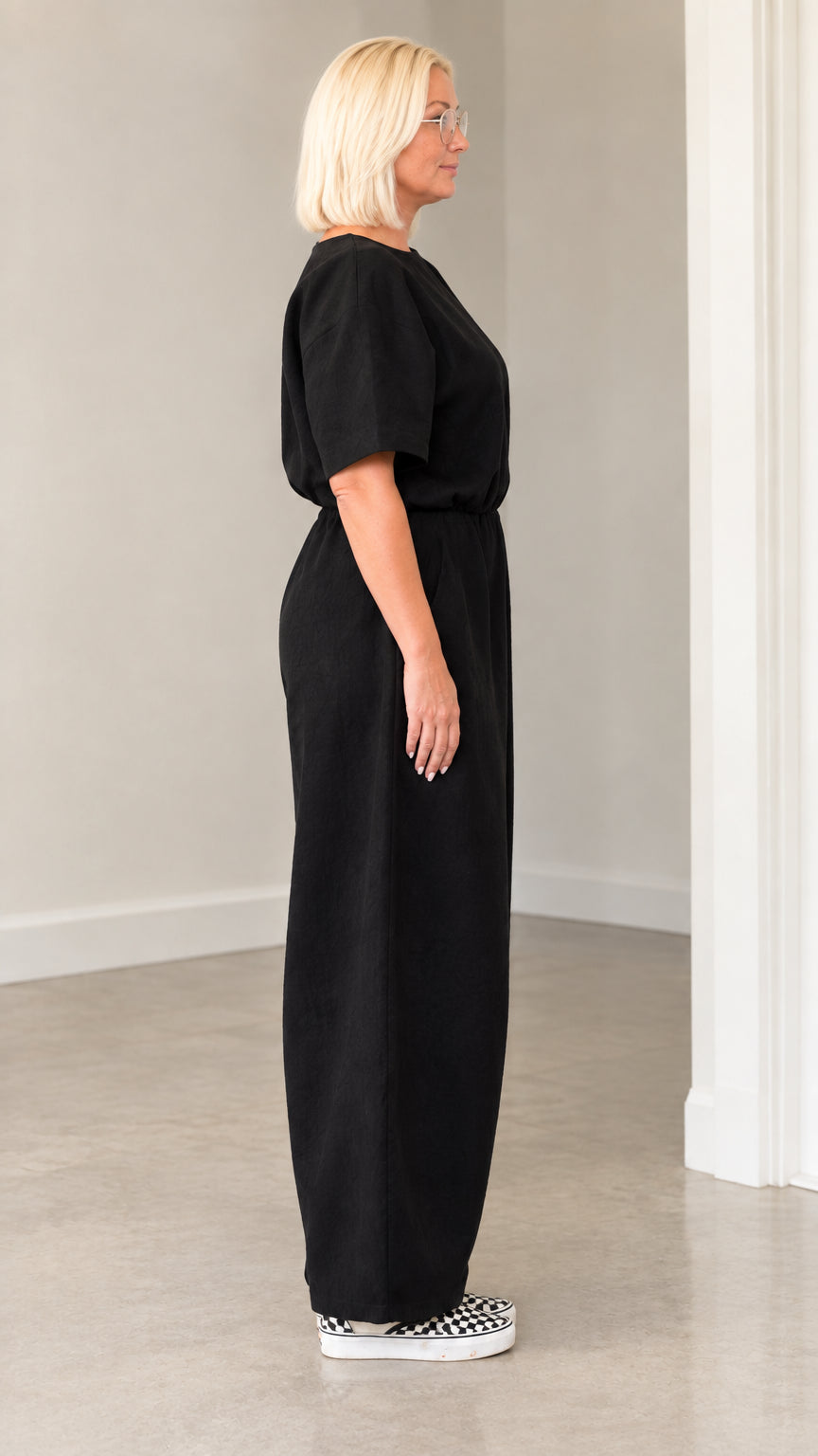 Side profile of woman in relaxed black lantern jumpsuit