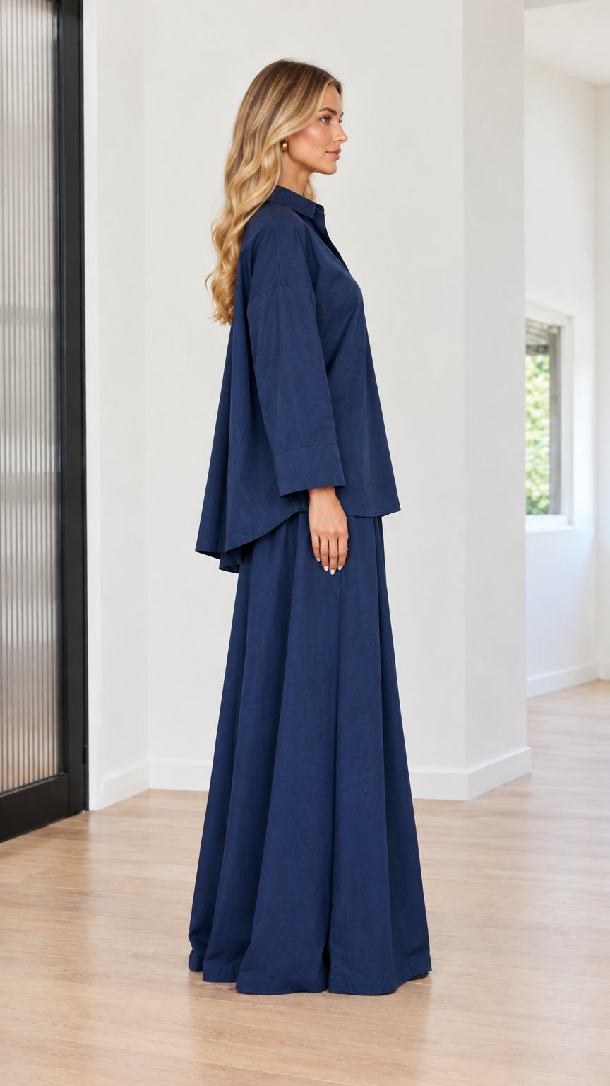 Side profile view of woman modeling navy blue long sleeve top and palazzo trousers set