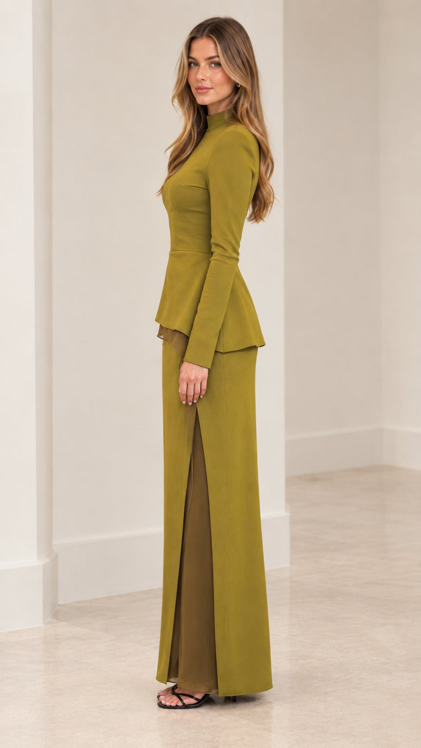 Side view of woman modeling olive green peplum top and slit maxi skirt two-piece set