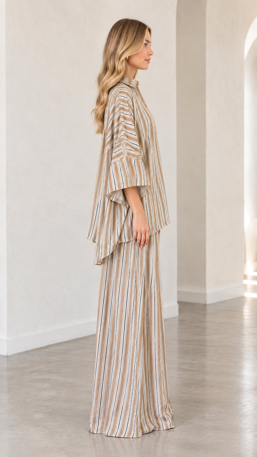 Side profile of woman wearing beige striped matching two-piece pant set