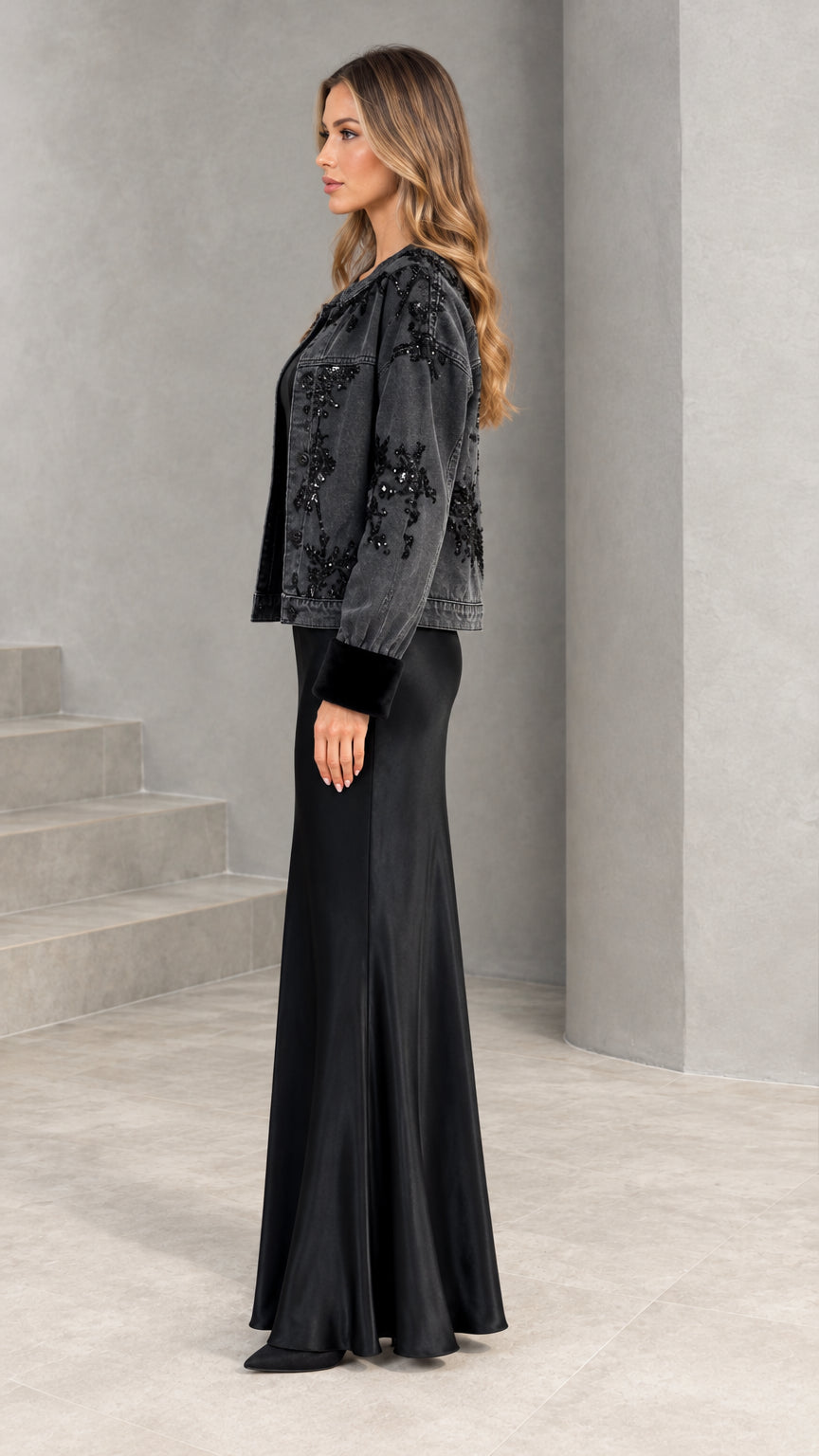 Side profile view of black two-piece embellished jacket and satin maxi dress