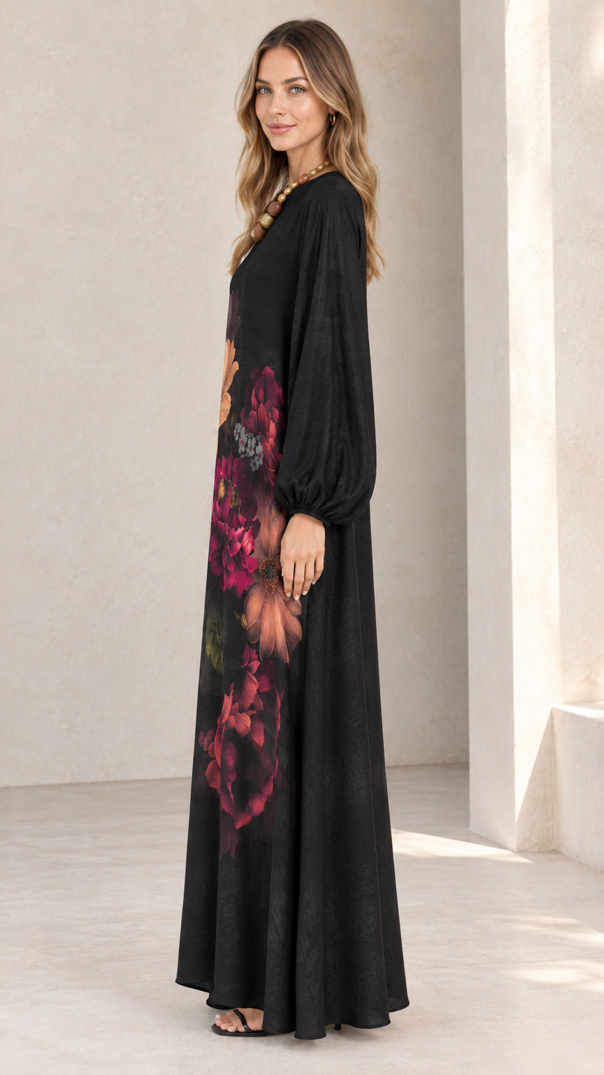 Side angle of model wearing black botanical print maxi dress