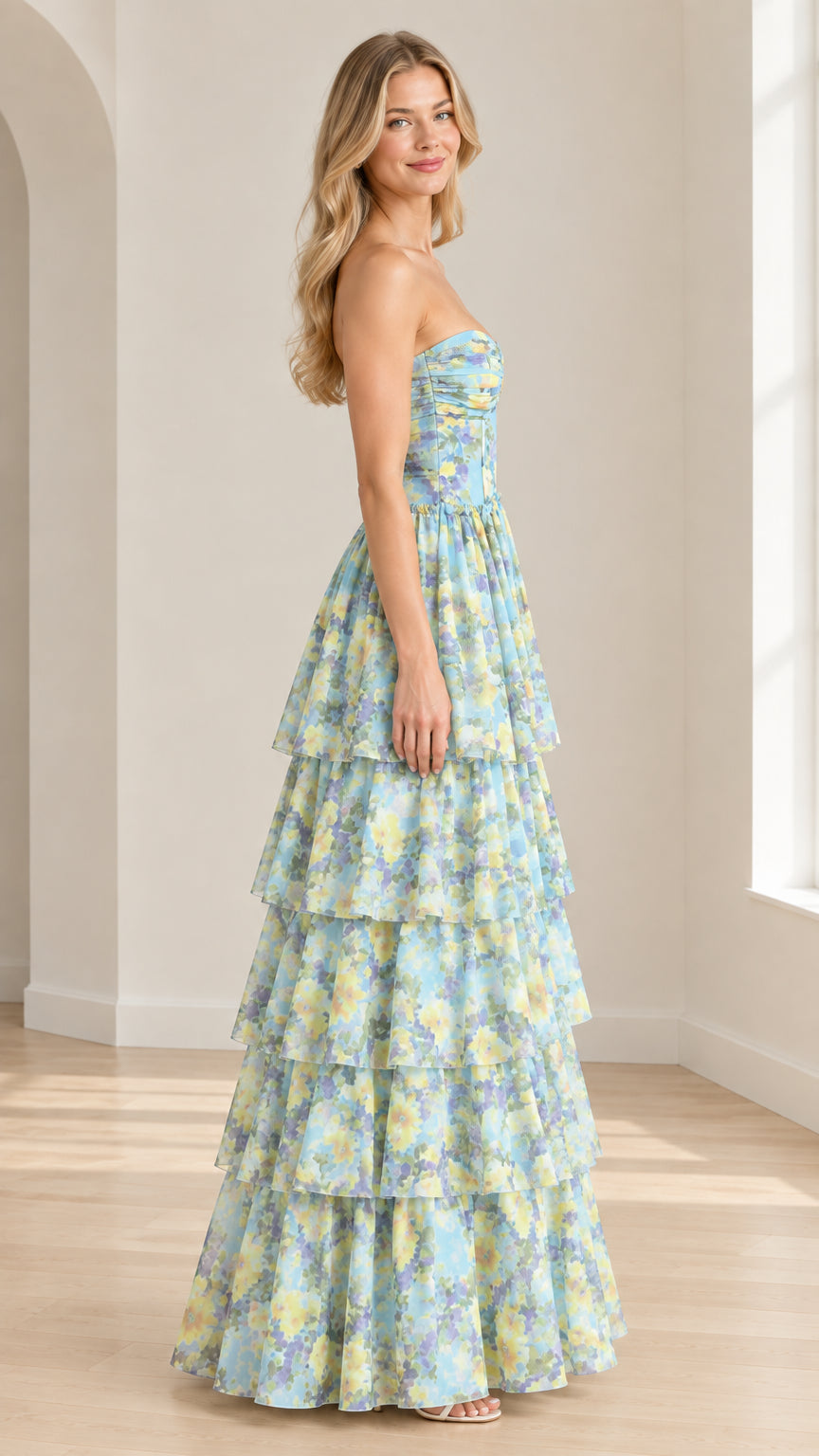 Side profile view of model in sky blue floral tiered strapless evening gown