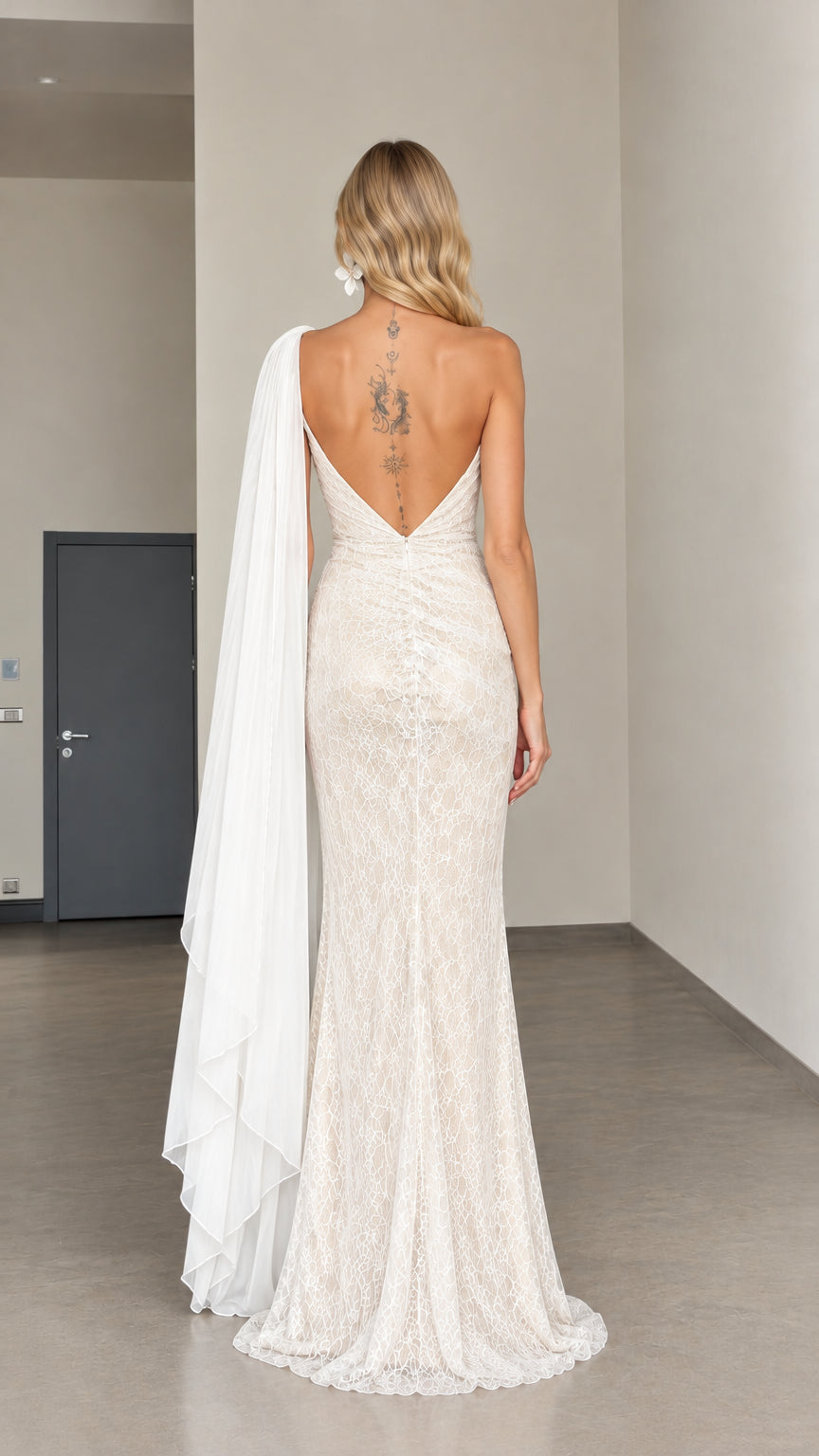 Back view of woman wearing ivory lace floor-length dress with open V-back and long cape train