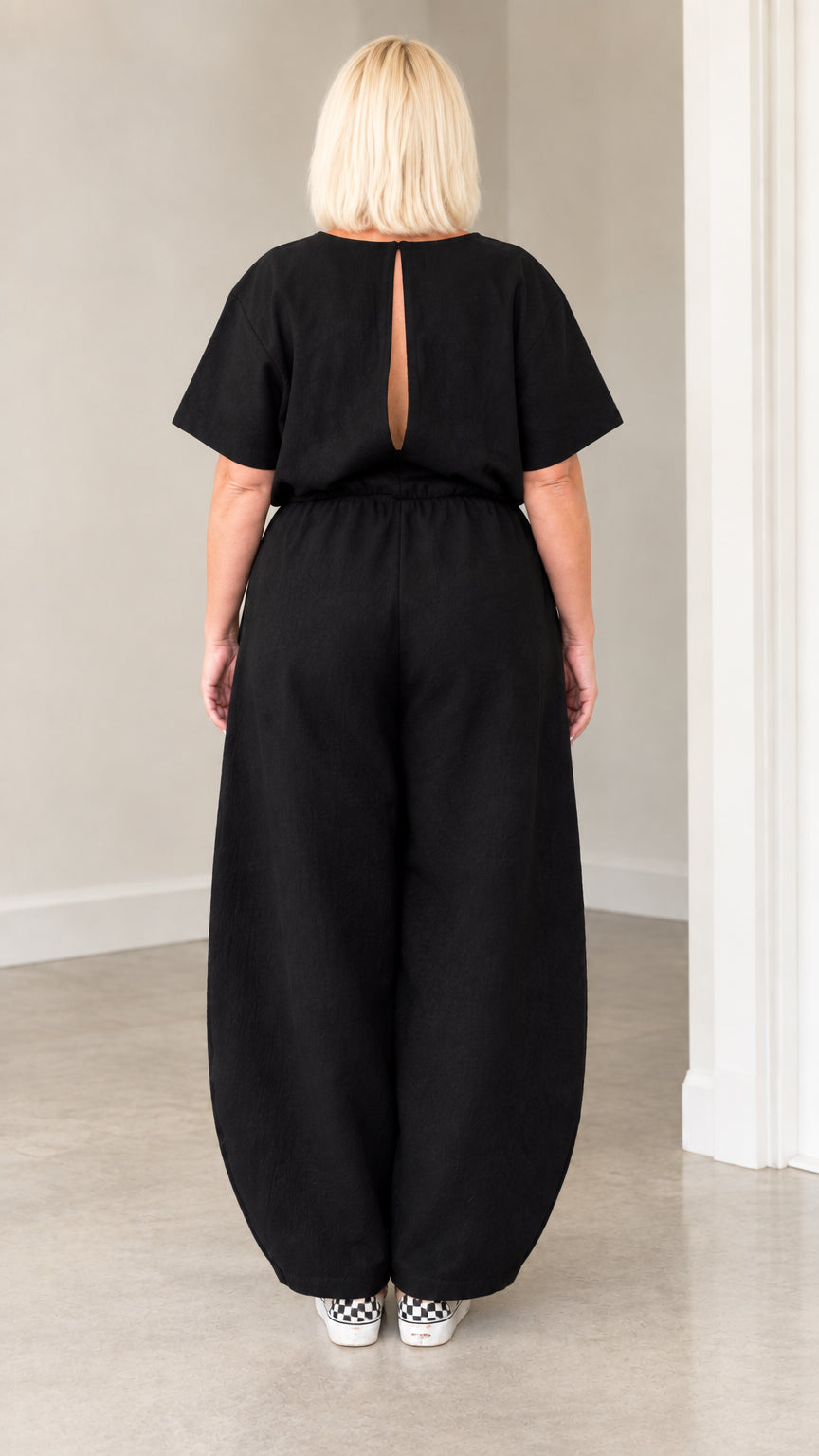 Back view of black jumpsuit highlighting the open keyhole slit cutout