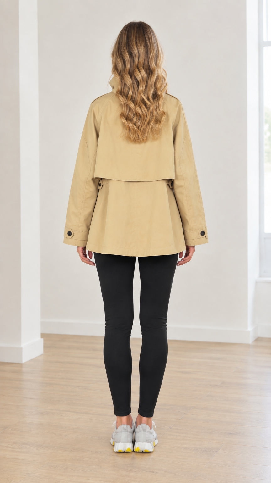 Back view of woman wearing khaki layered storm flap short trench coat