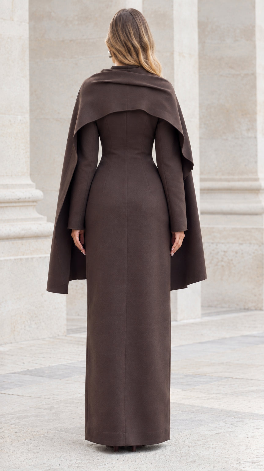 Back view of model showing the flowing drape of the brown capelet maxi suit