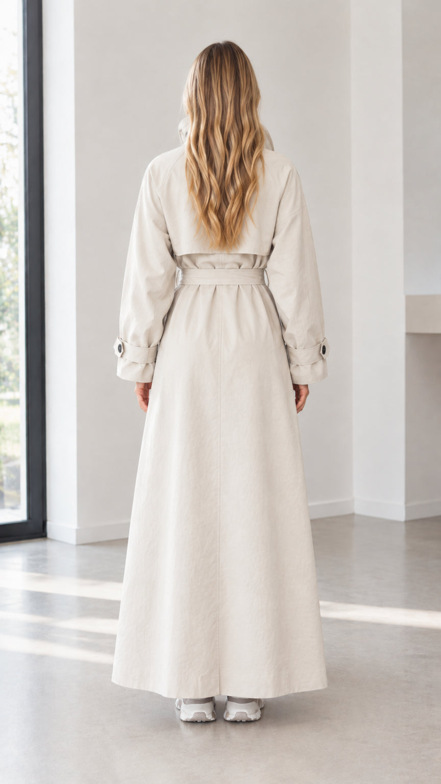 Back view of woman wearing beige maxi belted trench coat
