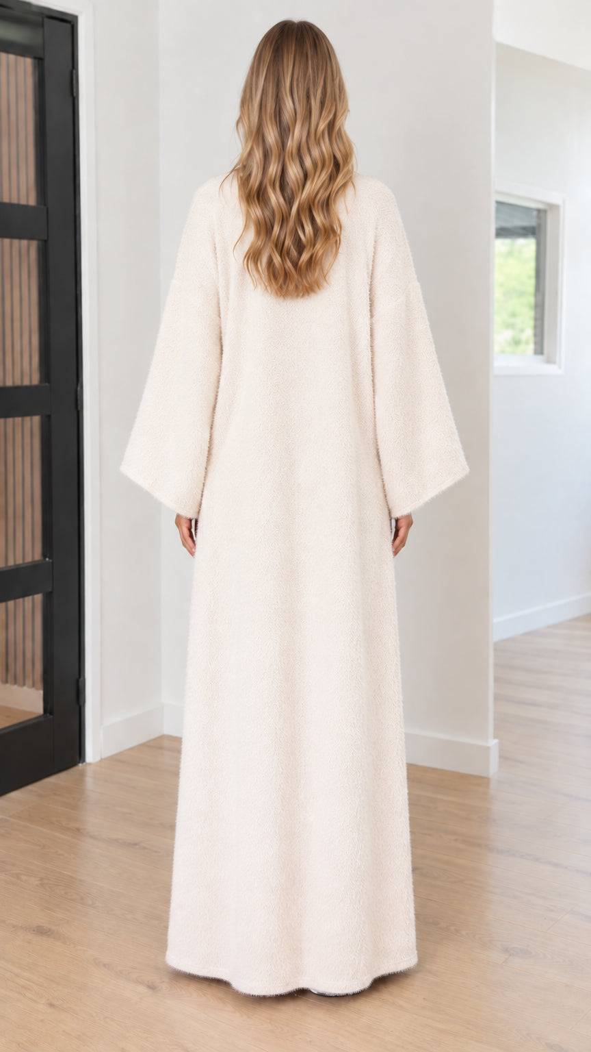 Back view of model wearing floor-length cream bouclé duster coat