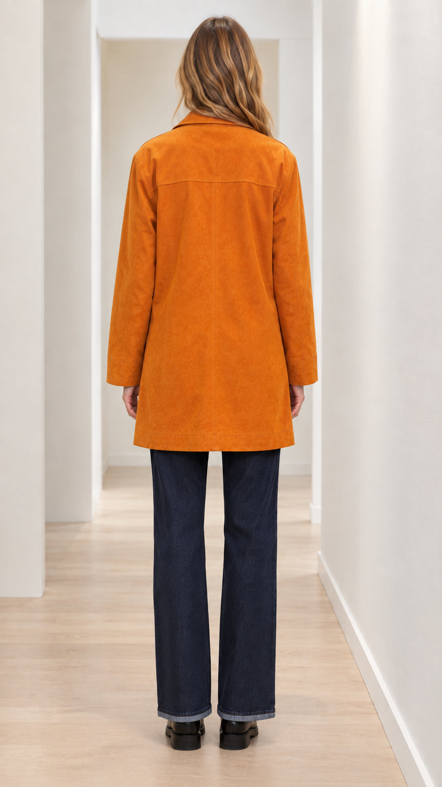 Back view of woman wearing cognac mid-length buttoned car coat