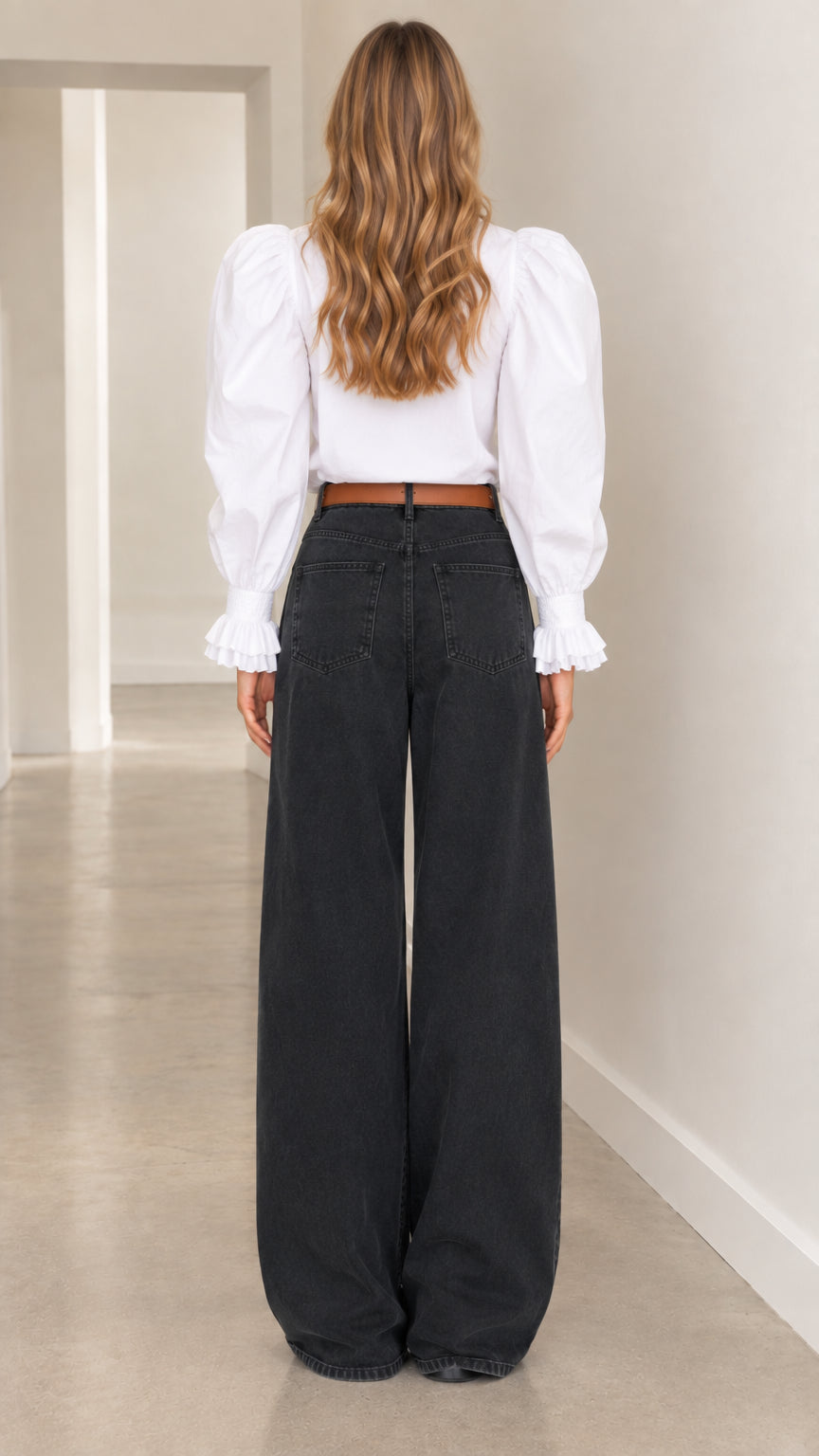 Back view of woman wearing white puff-sleeve blouse and dark wide-leg casual pants