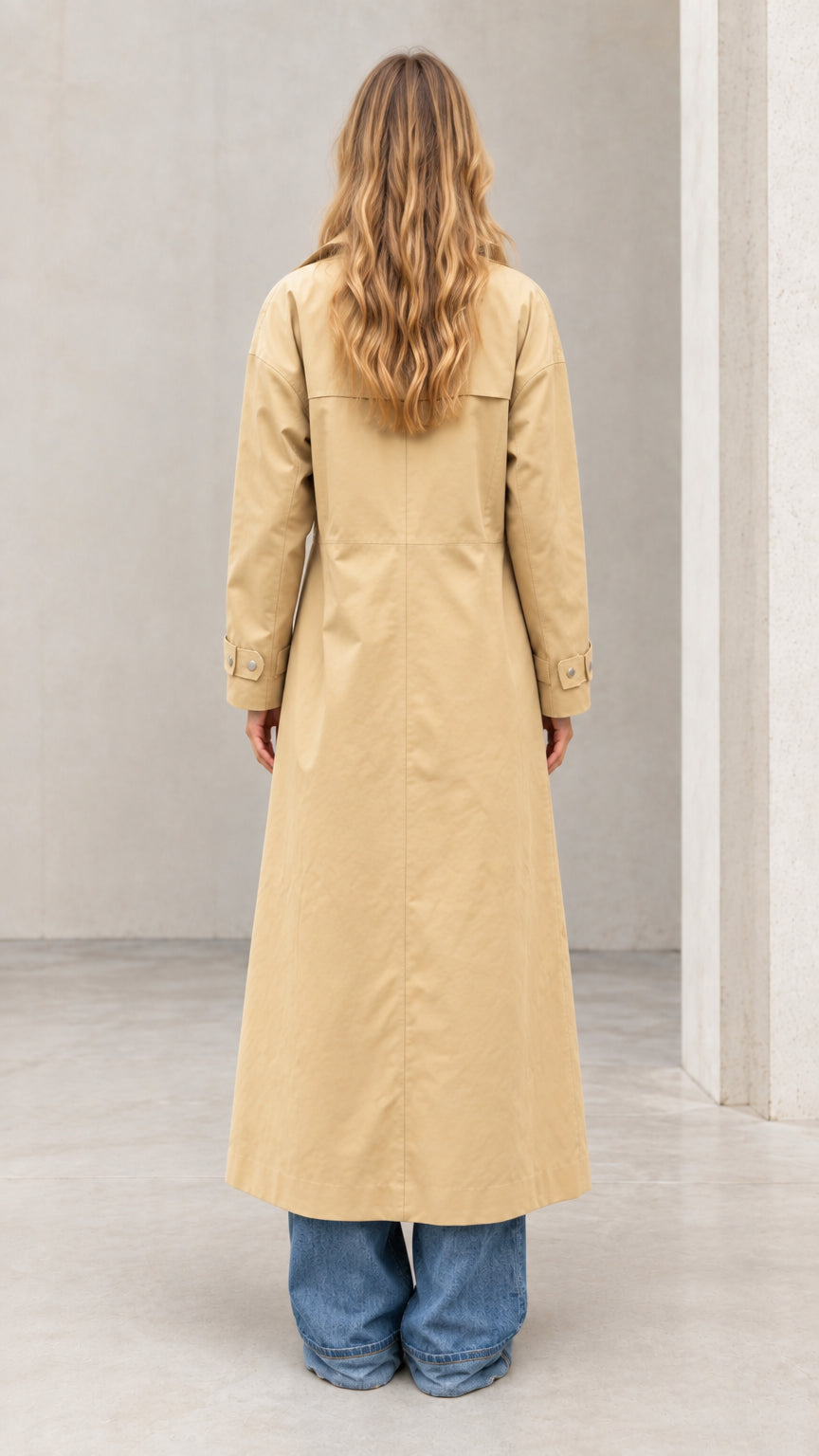 Back view of woman wearing full-length khaki trench coat