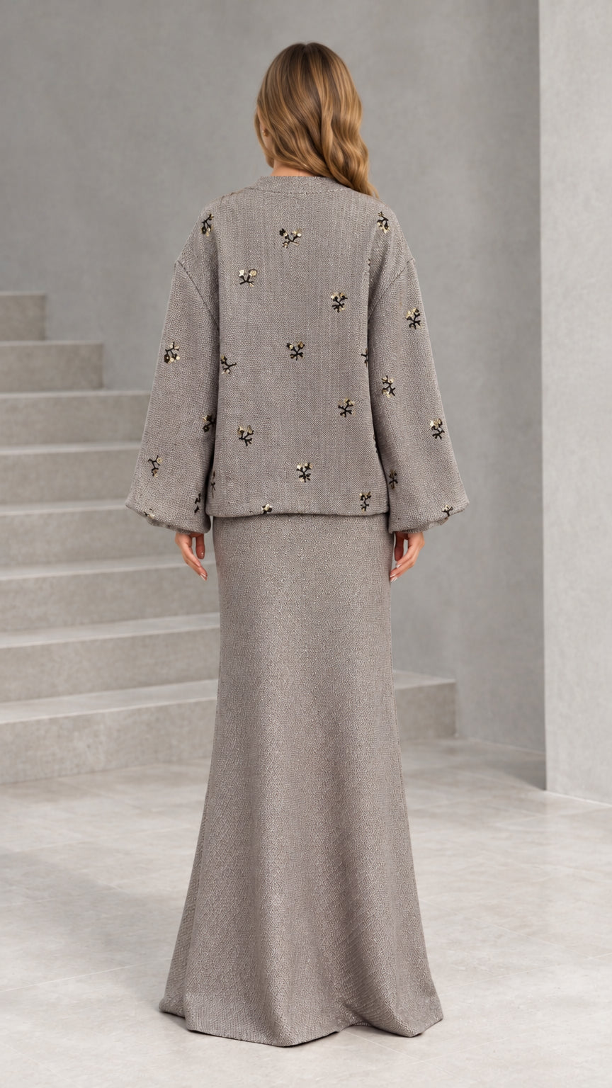 Back view of woman wearing taupe two-piece embellished skirt suit
