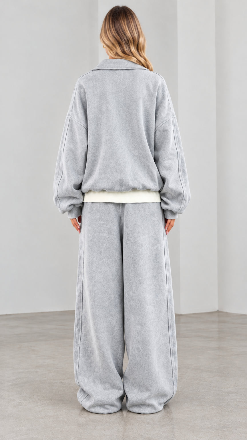 Back view of model wearing washed grey zip sweatshirt and wide-leg sweatpants