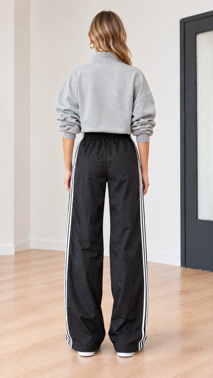 Back view of model wearing heather grey pullover and wide-leg track pants