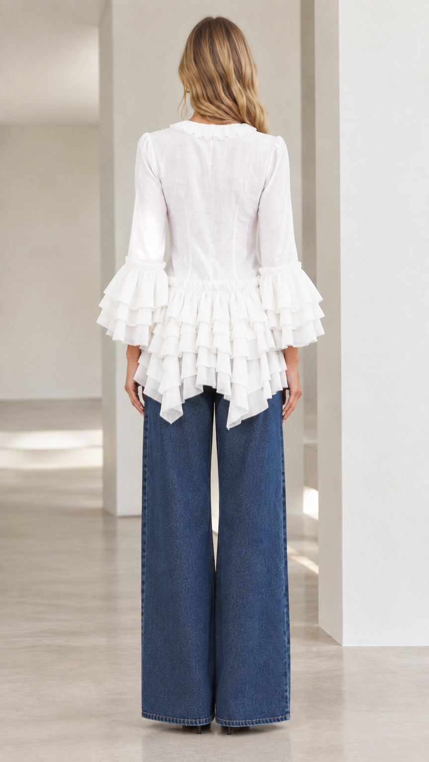 Back view of model wearing white tiered ruffle tunic top