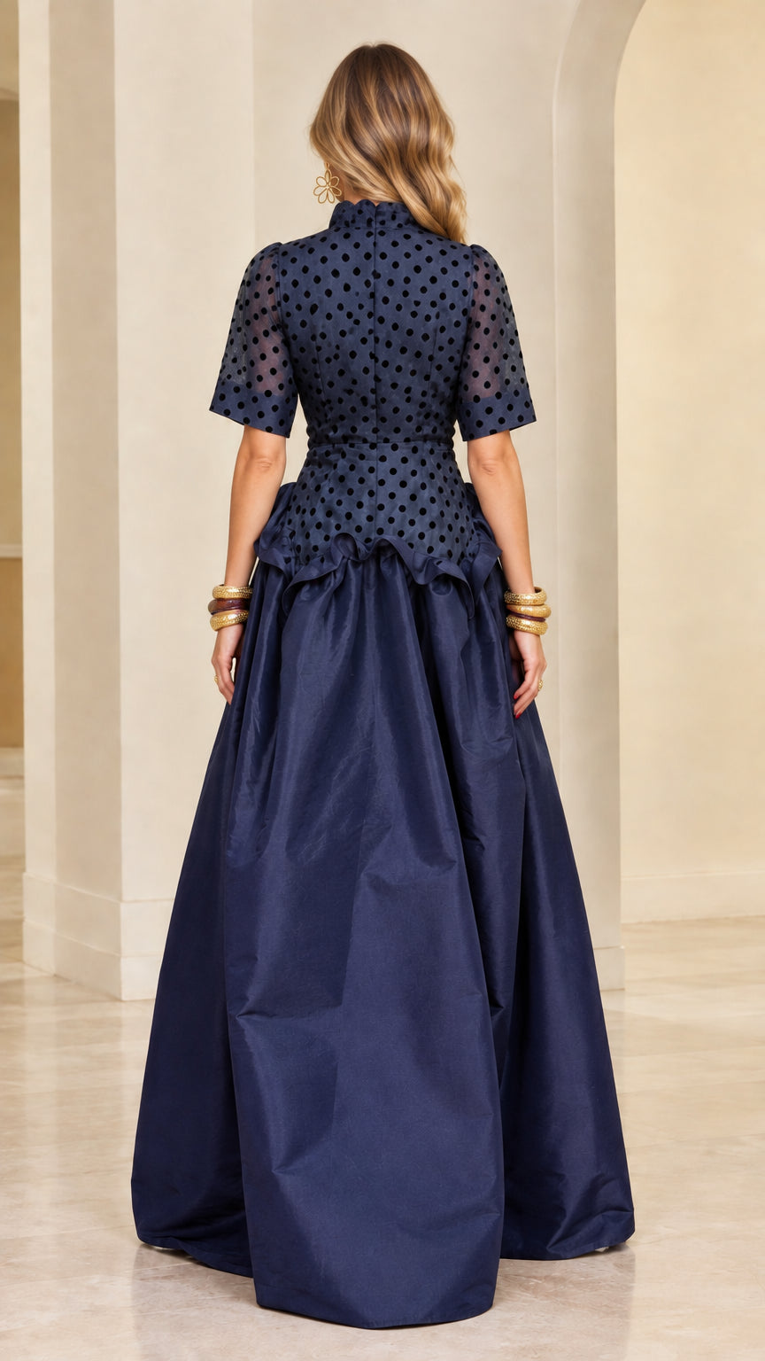 Model wearing navy blue polka dot evening gown - back view