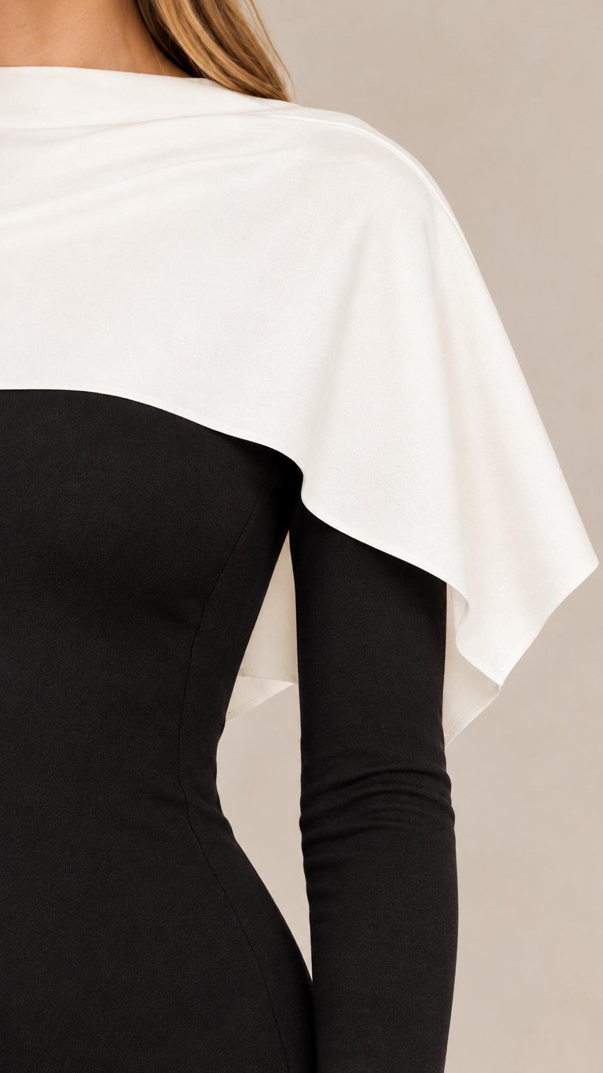 Close-up detail of white draped shoulder capelet on black bodice