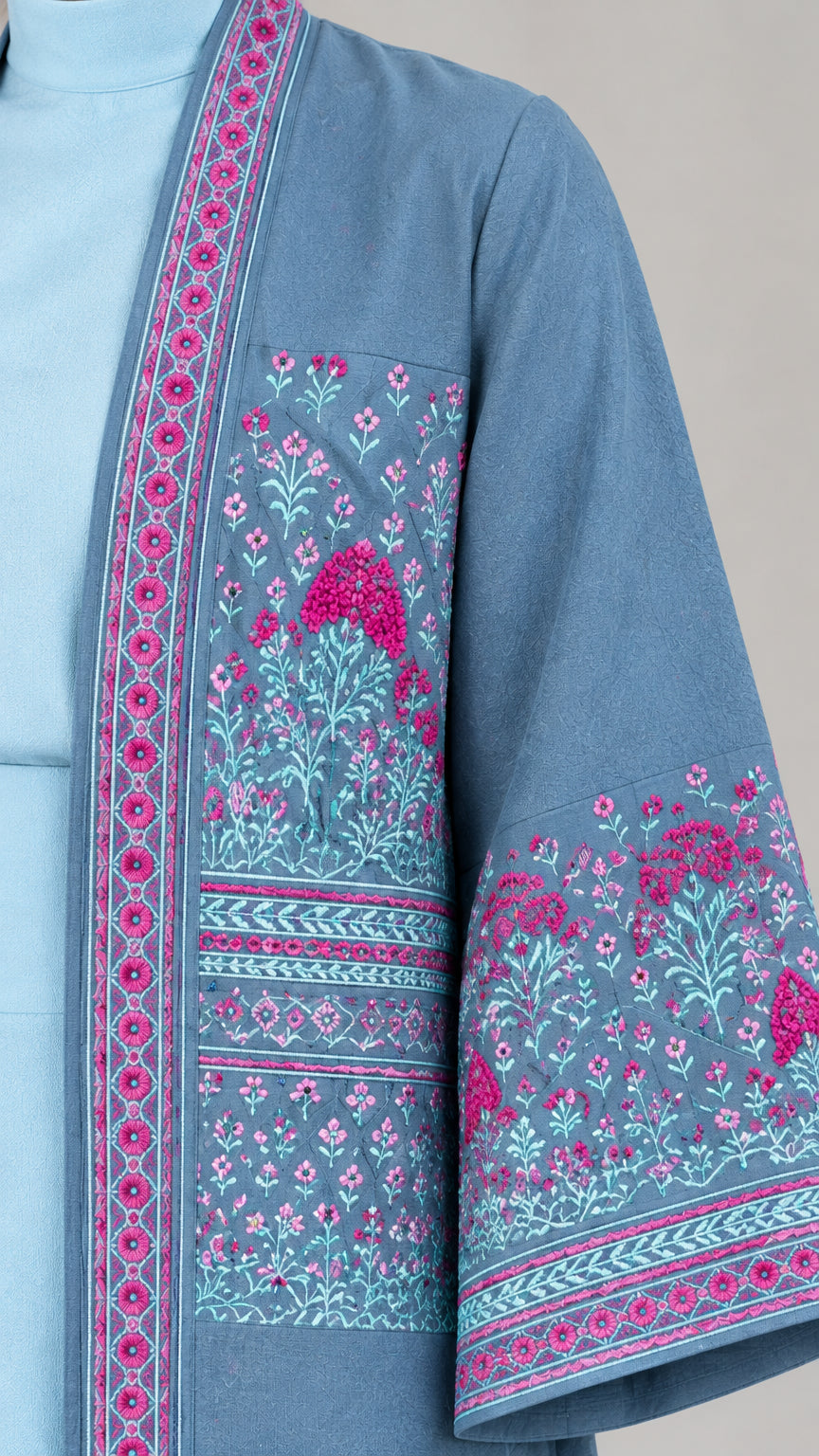 Close-up detail of floral and geometric embroidery on placket and sleeve cuff