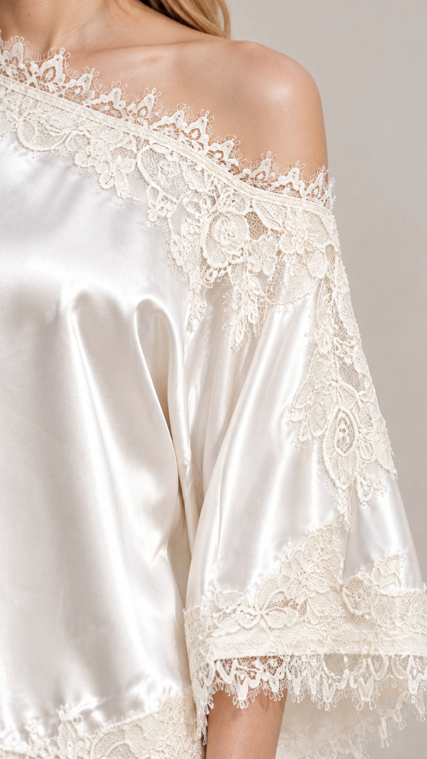 Close-up detail of delicate floral lace trim on Champagne satin fabric