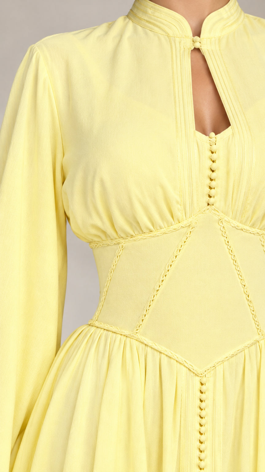 Close-up of pastel yellow dress showing keyhole cutout and corset waist detail