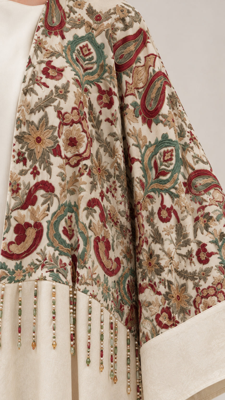 Close-up of intricate paisley floral embroidery and beaded tassel fringe