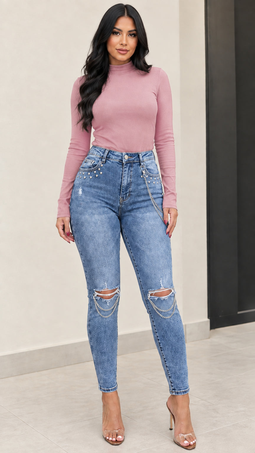 Front full view of medium blue chain distressed skinny jeans styled with a mauve long sleeve top