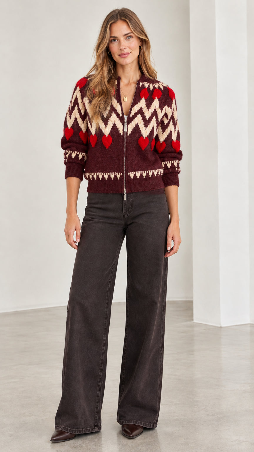 Front view of woman wearing burgundy chevron and red heart zip-up knit cardigan